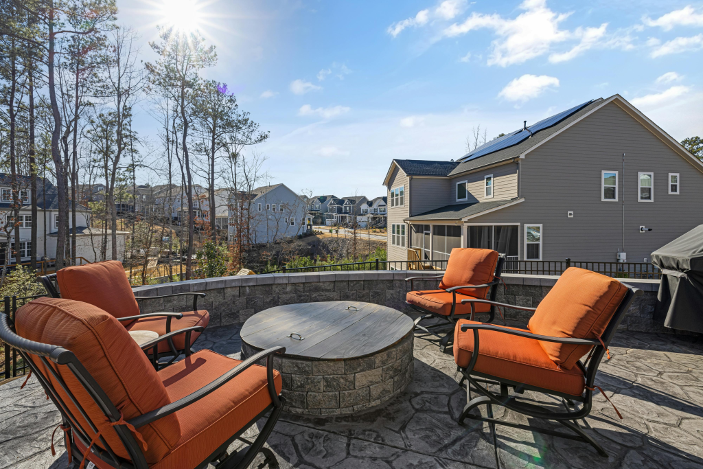Cozy outdoor patio with chairs and firepit overlooking a beautiful residential neighborhood.